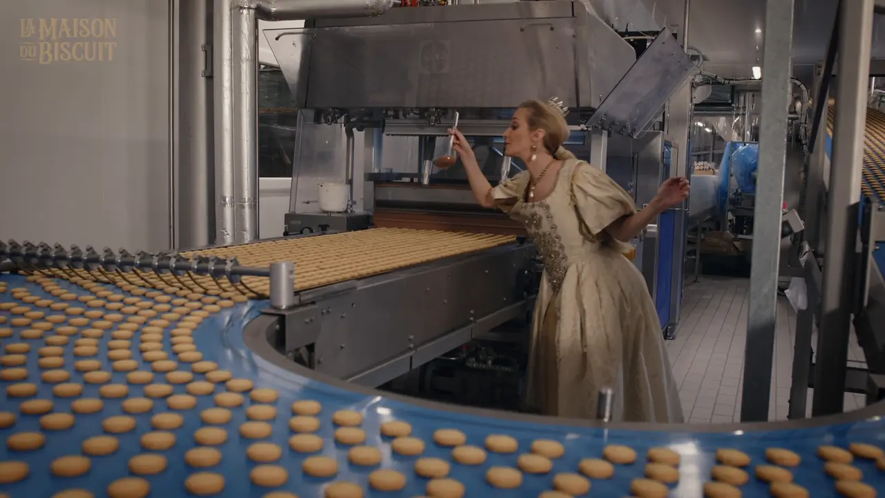Une princesse en robe de cour devant la ligne de production de biscuits, dans l’épisode Peau d’Âne