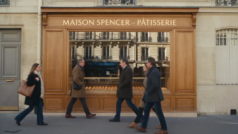 Des passants marchent devant la vitrine de la pâtisserie sans s’arrêter